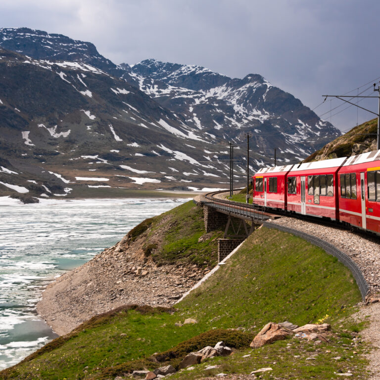 Red train going in beautiful landscape, Switzerland